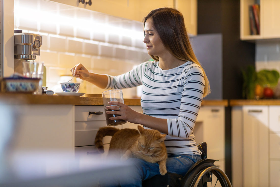 Woman in wheelchair at home with cat