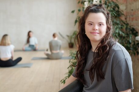 A woman with a grey top and down syndrome is contemplating her own change of circumstances and looking for sDA 