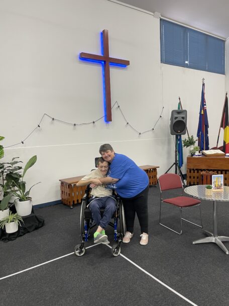 At their local church, Ryan and Sheree hug Infront of the cross.